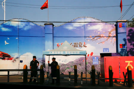 FILE PHOTO: Security guards stand at the gates of what is officially known as a vocational skills education centre in Huocheng County in Xinjiang Uighur Autonomous Region, China September 3, 2018. REUTERS/Thomas Peter/File Photo