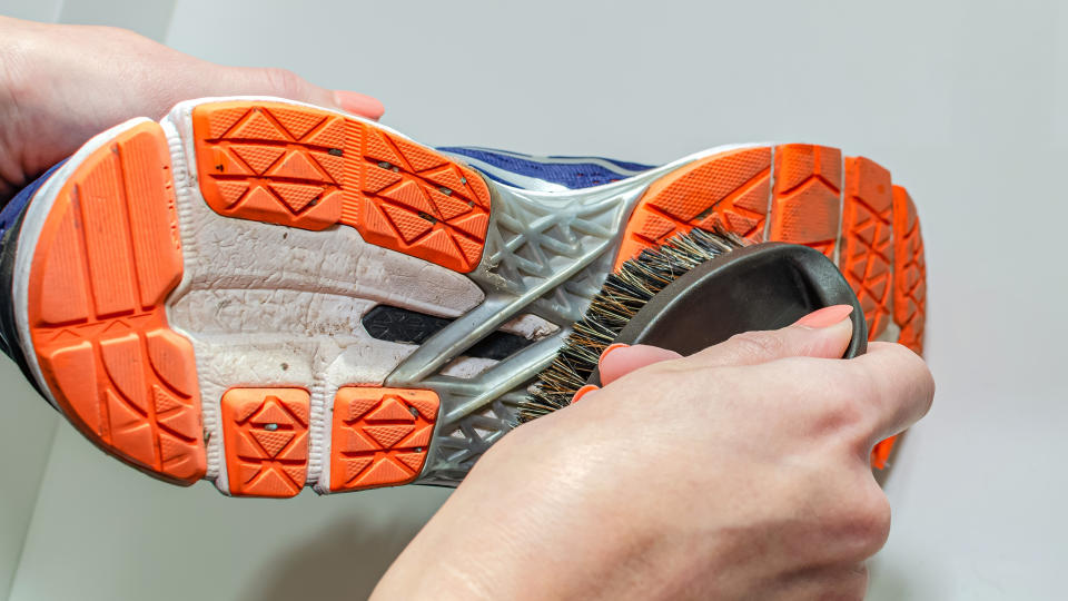 Person scrubbing sport shoe sole