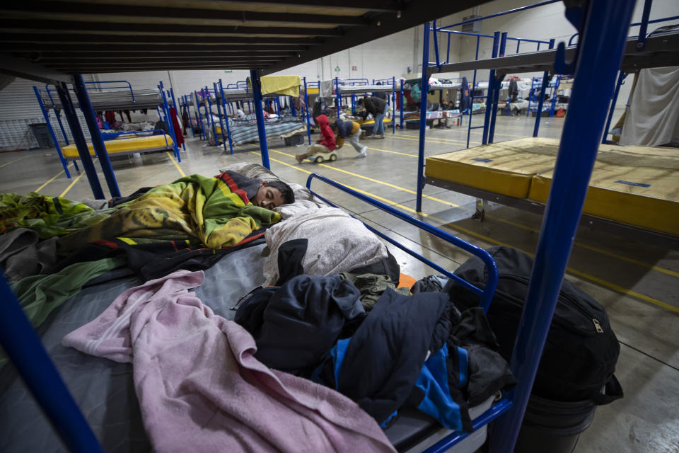 A migrant child sleeps at a government-run shelter in Ciudad Juarez, Mexico, on Sunday, Dec. 18, 2022. (AP Photo/Andres Leighton)