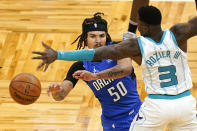 Orlando Magic guard Cole Anthony (50) passes the ball around Charlotte Hornets guard Terry Rozier (3) during the second half of an NBA basketball game, Sunday, Jan. 24, 2021, in Orlando, Fla. (AP Photo/John Raoux)