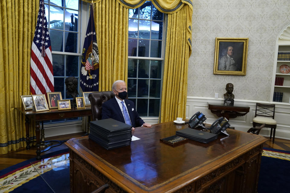 FILE - In this Wednesday, Jan. 20, 2021 file photo, President Joe Biden pauses as he signs his first executive orders in the Oval Office of the White House in Washington. On Friday, Feb. 12, 2021, The Associated Press reported on a manipulated photo circulating online incorrectly asserting it shows President Joe Biden asleep in his seat at the Resolute Desk in the Oval Office with a stack of executive orders in front of him. Biden’s head in the post comes from a 2011 event where he appears to briefly doze off as former President Barack Obama delivered a speech on the national debt. (AP Photo/Evan Vucci)