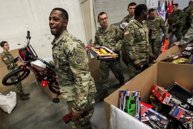 First Sgt. Andre Bland carries a bike to donate at the 2017 Top Drop. The U.S. Army Civil Affairs and Psychological Operations command is rebooting the event and calling it the 2022 Randy Oler Memorial Operation Toy Drop 2.0.