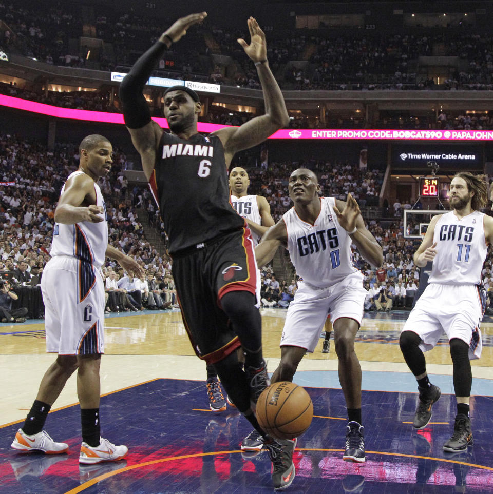Miami Heat's LeBron James (6) is fouled as he drives past Charlotte Bobcats' Bismack Biyombo (0) during the first half in Game 4 of an opening-round NBA basketball playoff series in Charlotte, N.C., Monday, April 28, 2014. (AP Photo/Chuck Burton)