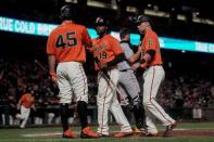 Aug 10, 2018; San Francisco, CA, USA; San Francisco Giants starting pitcher Derek Holland (45) and second baseman Alen Hanson (19) and second baseman Joe Panik (12) celebrate against the Pittsburgh Pirates during the fourth inning at AT&T Park. Mandatory Credit: Stan Szeto-USA TODAY Sports