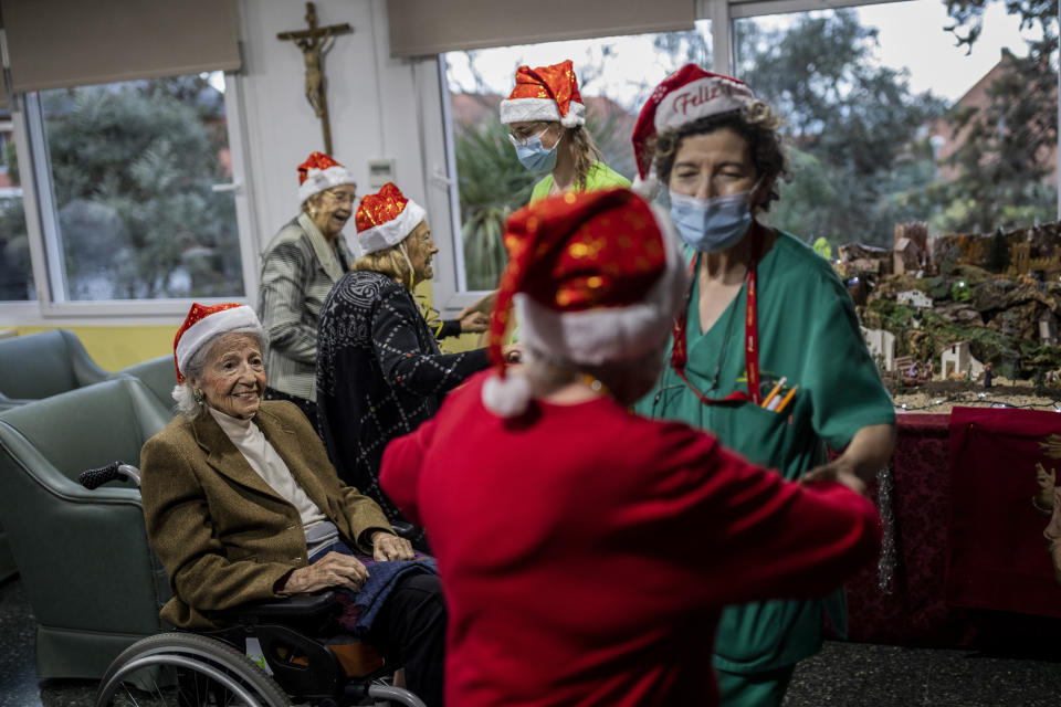 Residents of an elderly care home celebrate Christmas Eve in Pozuelo de Alarcon, outskirts of Madrid, Thursday, Dec. 24, 2020. Many of the elderly in the residence haven't celebrate Christmas Eve with their relatives to prevent the spread of coronavirus (AP Photo/Bernat Armangue)