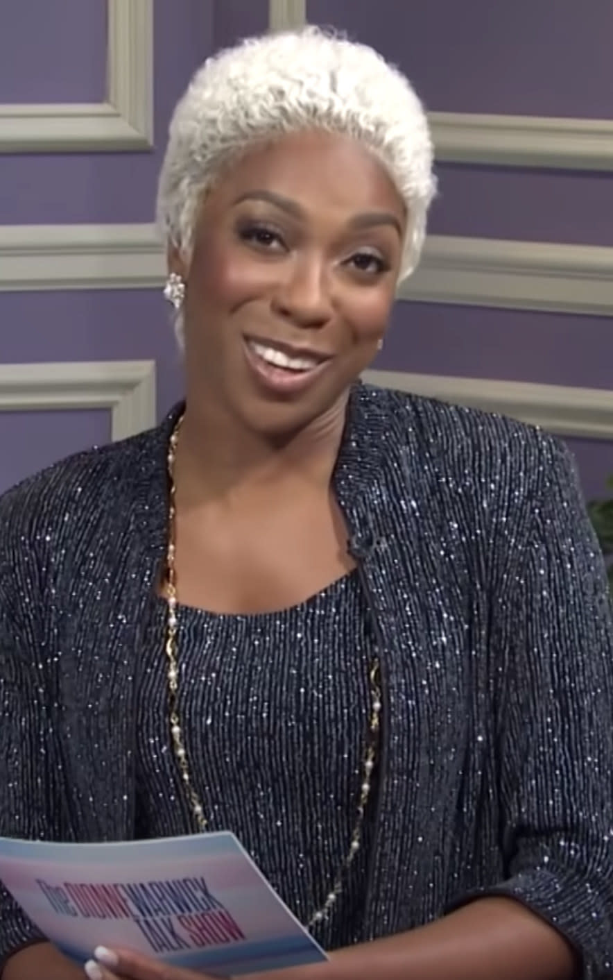Nwodim wearing a grey wig and sequined suit
