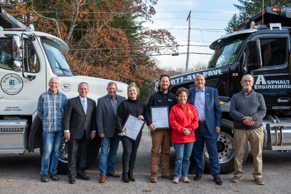 Denis Fraine, can be seen on the left of this 2021 photo with other community adn business leaders, as they announce two local companies, Asphalt Engineering and Riley Brother Inc., were volunteering their services and materials to update the Bellingham VFW lot.