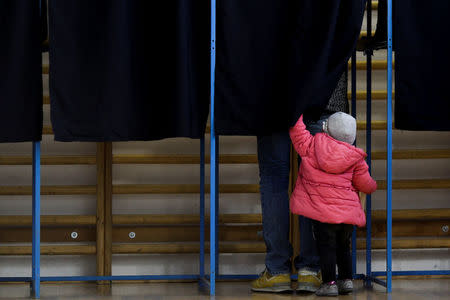 A girl looks inside the polling booth where her father votes for parliamentary elections, in Bucharest, Romania, December 11, 2016. Inquam Photos/Octav Ganea/via REUTERS