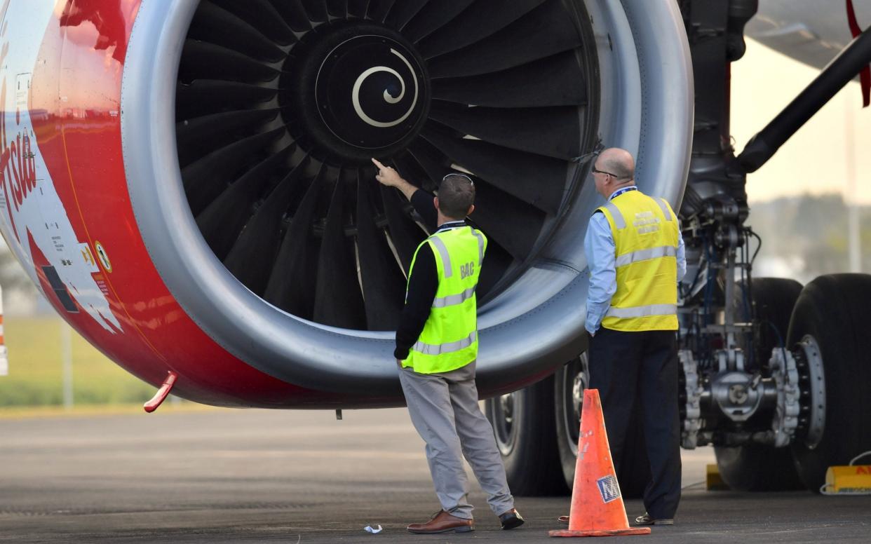 Officials inspect an engine of Malaysian budget carrier AirAsia X after it was diverted and forced to land because an engine was damaged during take-off  - REUTERS
