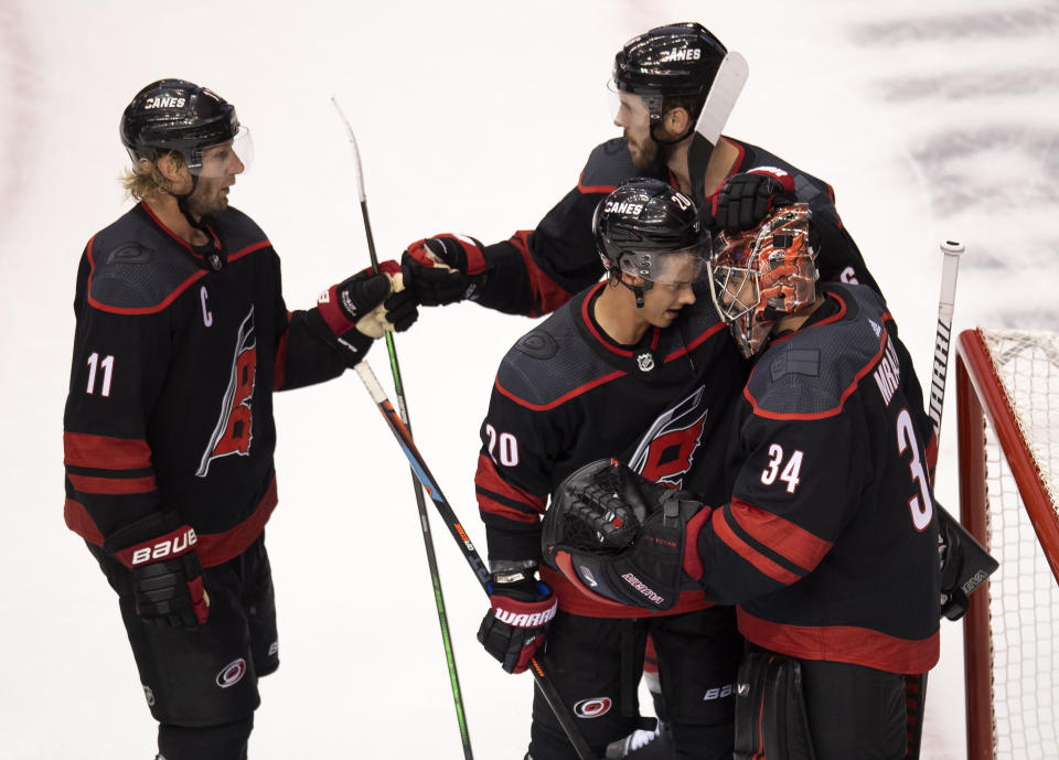 Carolina Hurricanes' Jordan Staal (11), Joel Edmundson (6), Sebastian Aho (20) and goaltender Petr Mrazek (34) celebrate their win against the New York Rangers in the NHL hockey Stanley Cup playoffs in Toronto, Saturday, Aug. 1, 2020. (Frank Gunn/The Canadian Press via AP)