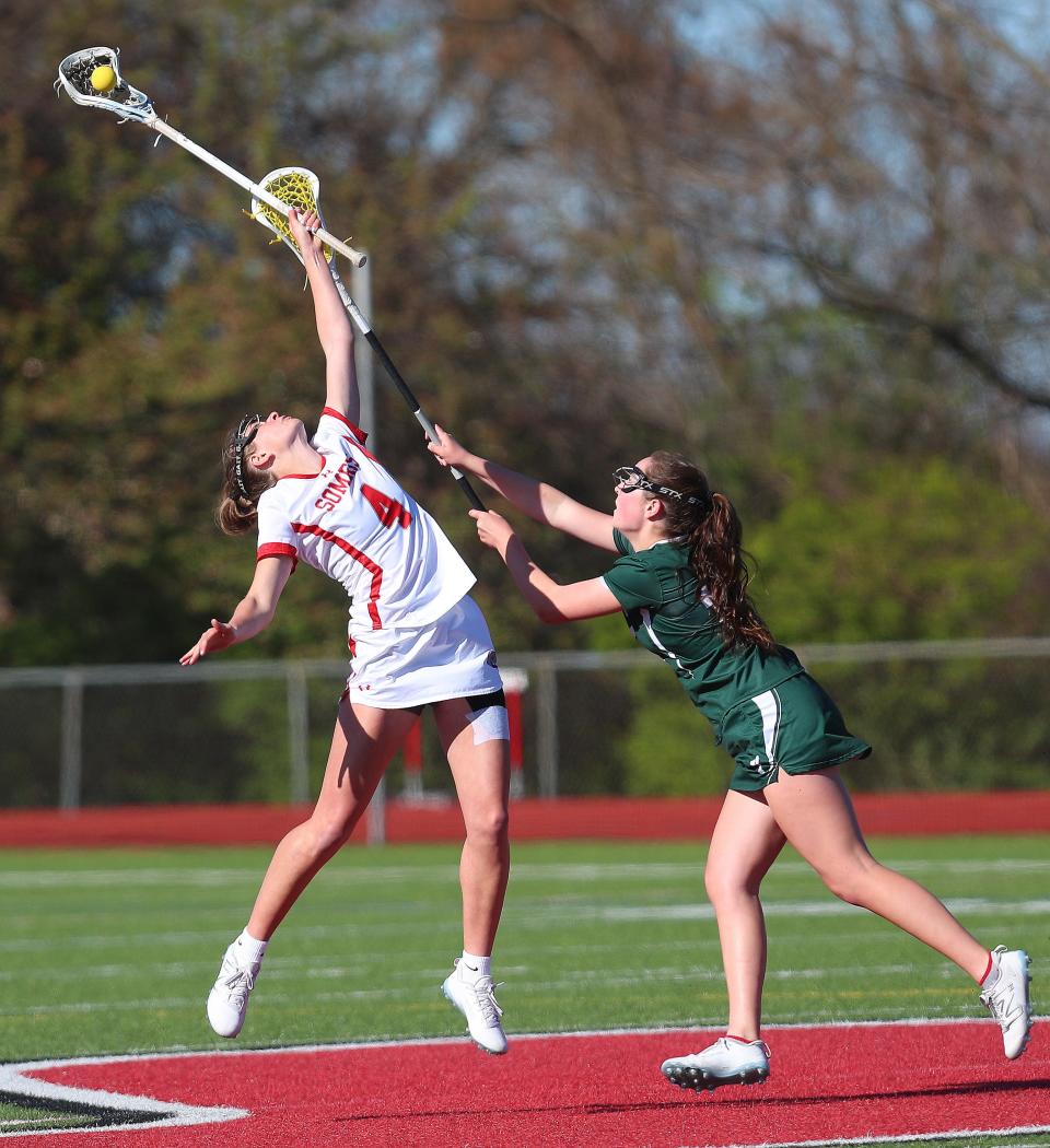 Somers Sydney Ingram (4) controls a face-off in front of YorktownÕs Ava Cunneen (25) during girls lacrosse action at Somers High School April 25, 2024. Yorktown won the game 8-5.