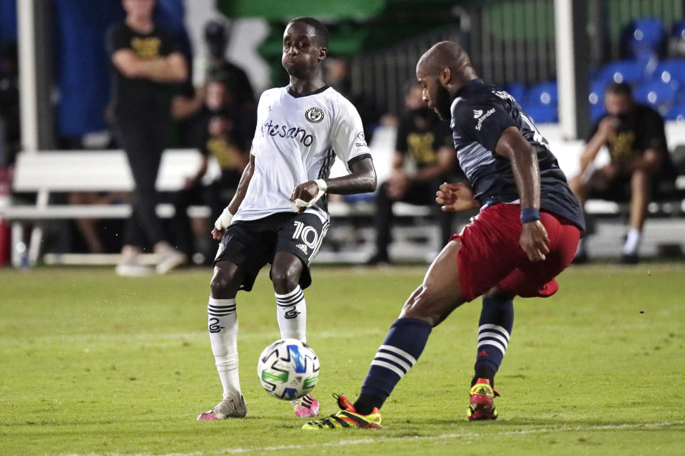 New England Revolution defender Andrew Farrell works the ball against Philadelphia Union midfielder Jamiro Monteiro during the second half of an MLS soccer match, Sunday, July 26, 2020, in Kissimmee, Fla. (AP Photo/John Raoux)