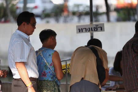 Thailand's Prime Minister Prayuth Chan-ocha (L) prepares to vote in the general election at a polling station in Bangkok, Thailand, March 24, 2019. REUTERS/Athit Perawongmetha