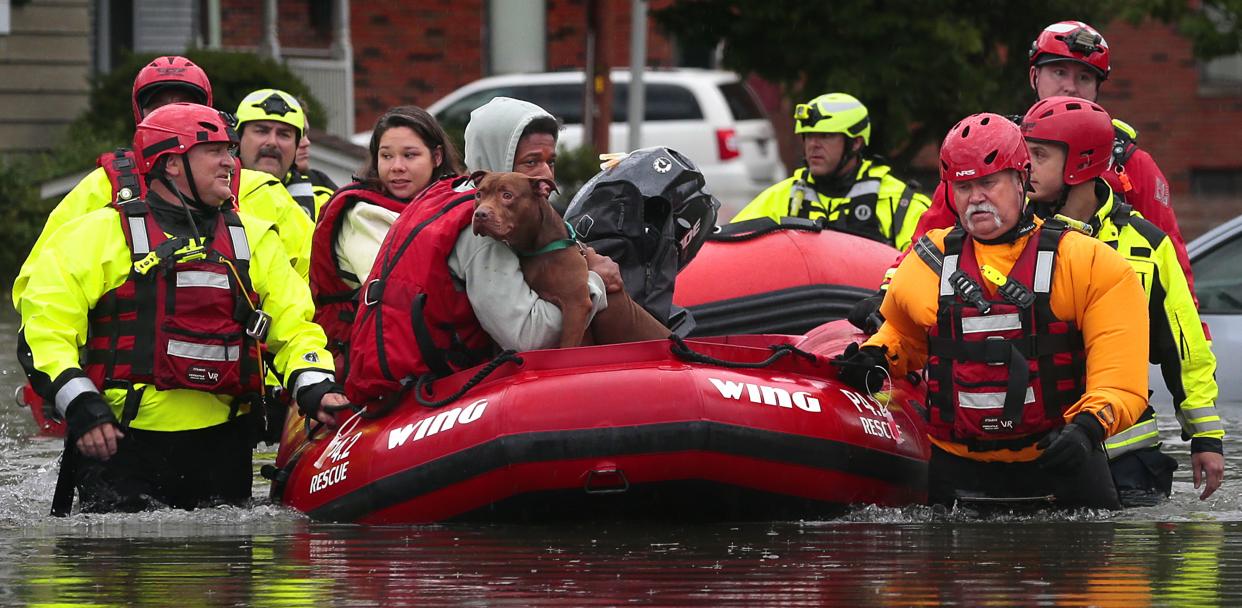 Matthew Robinson holds onto his dog Bebe as and Kimberly Tat are rescued from their home by first responders from Central County Fire and Rescue along Main Street in Old Towne St. Peters after flooding from Dardenne Creek inundated the neighborhood during heavy rains on Tuesday, July 26, 2022. 