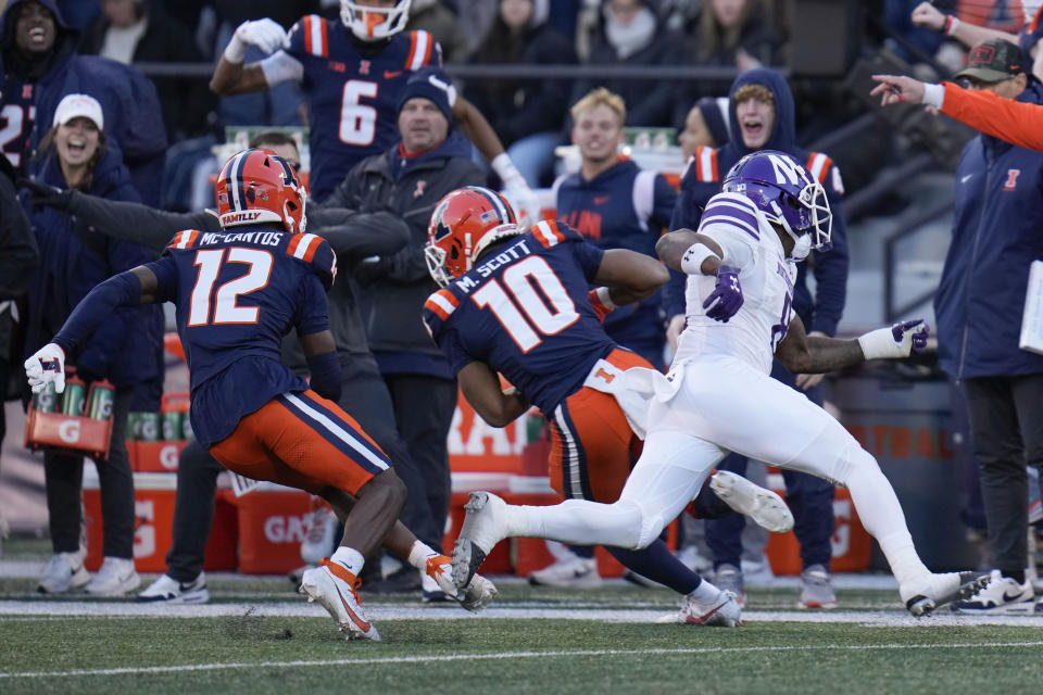 Illinois defensive back Miles Scott (10) intercepts a pass meant for Northwestern wide receiver A.J. Henning, right, before running in a touchdown during the first half of an NCAA college football game Saturday, Nov. 25, 2023, in Champaign, Ill. (AP Photo/Erin Hooley)