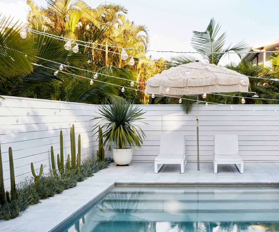 pool with festoon lights and sun loungers