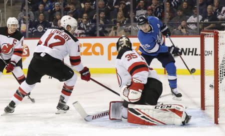 Nov 11, 2018; Winnipeg, Manitoba, CAN; Winnipeg Jets center Mark Scheifele (55) scores on New Jersey Devils goaltender Cory Schneider (35) in the second period at Bell MTS Place. James Carey Lauder-USA TODAY Sports