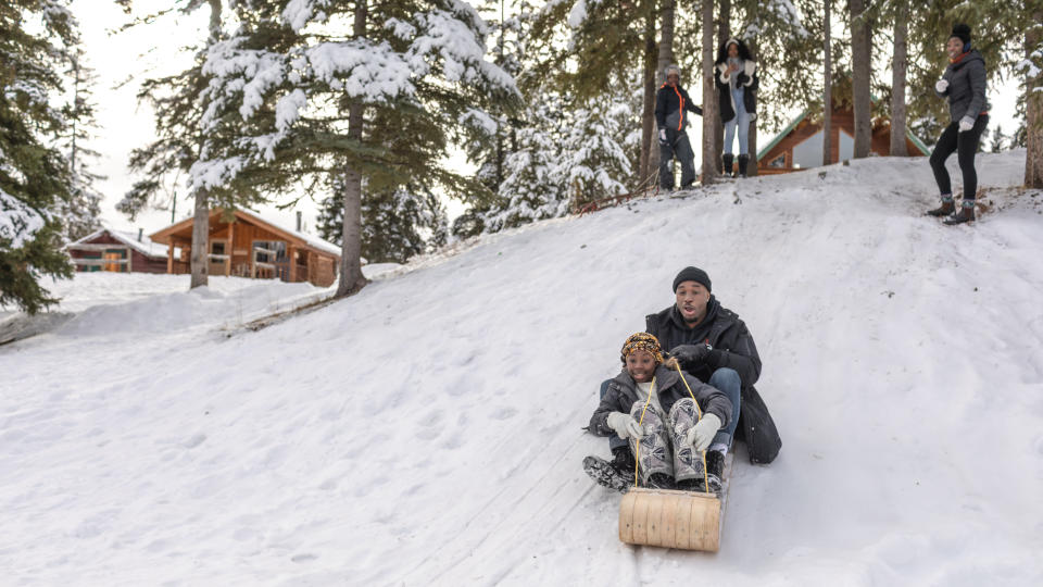 A family sledding in an alpine setting