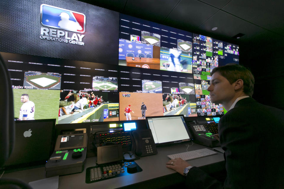 Chris Marinak sits in front of a bank of television screens during a preview of Major League Baseball's Replay Operations Center, in New York, Wednesday, March 26, 2014. Less than a week before most teams open, MLB is working on the unveiling of its new instant replay system, which it hopes will vastly reduce incorrect calls by umpires. (AP Photo/Richard Drew)