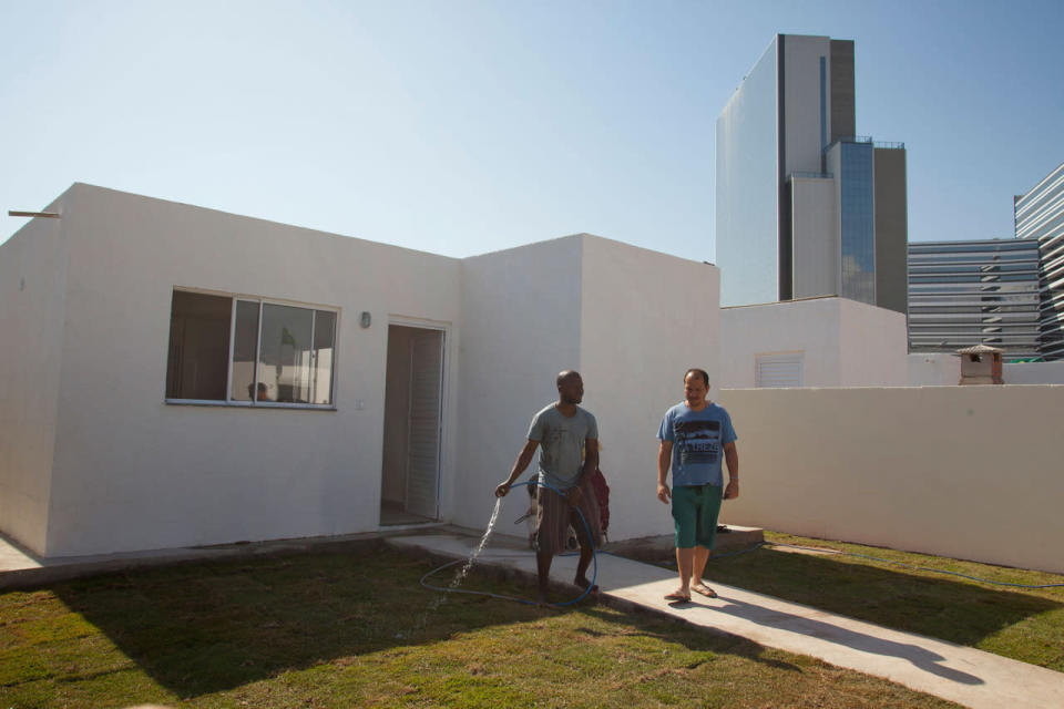 <p>Residents who stayed on move into their new Government built homes, with the Olympic park shining in the background. Vila Autodromo favela, in the west zone of Rio, is in direct site of the Rio 2016 Olympic park. (Phil Clarke Hill/In Pictures via Getty Images)</p>