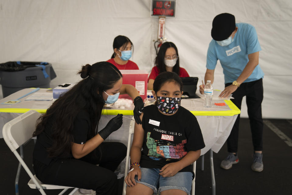 FILE - In this Aug. 28, 2021, file photo, Mayra Navarrete, 13, receives the Pfizer COVID-19 vaccine from registered nurse, Noleen Nobleza at a clinic set up in the parking lot of CalOptima in Orange, Calif. With more than 40 million doses of coronavirus vaccines available, U.S. health authorities said they're confident both seniors and other vulnerable Americans seeking booster shots and parents anticipating approval of initial shots for young children will have easy access. (AP Photo/Jae C. Hong, File)