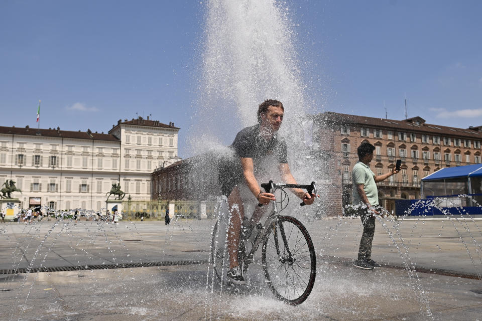 TURIN, ITALY - JULY 11: A man rides a bicycle inside a fountain in Piazza Castello on July 11, 2023 in Turin, Italy. The record for the highest temperature in European history was broken in August 2021, when 48.8C was registered in Floridia, a town in Italy's Sicilian province of Syracuse. (Photo by Stefano Guidi/Getty Images)