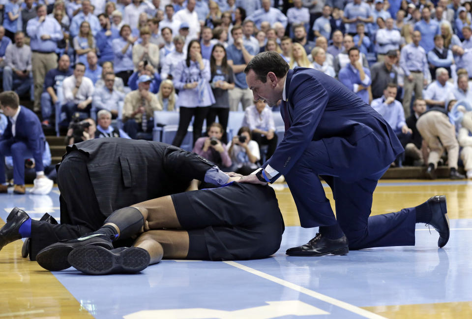 Duke head coach Mike Krzyzewski checks on an injured Marques Bolden during the first half of an NCAA college basketball game against North Carolina in Chapel Hill, N.C., Saturday, March 9, 2019. (AP Photo/Gerry Broome)