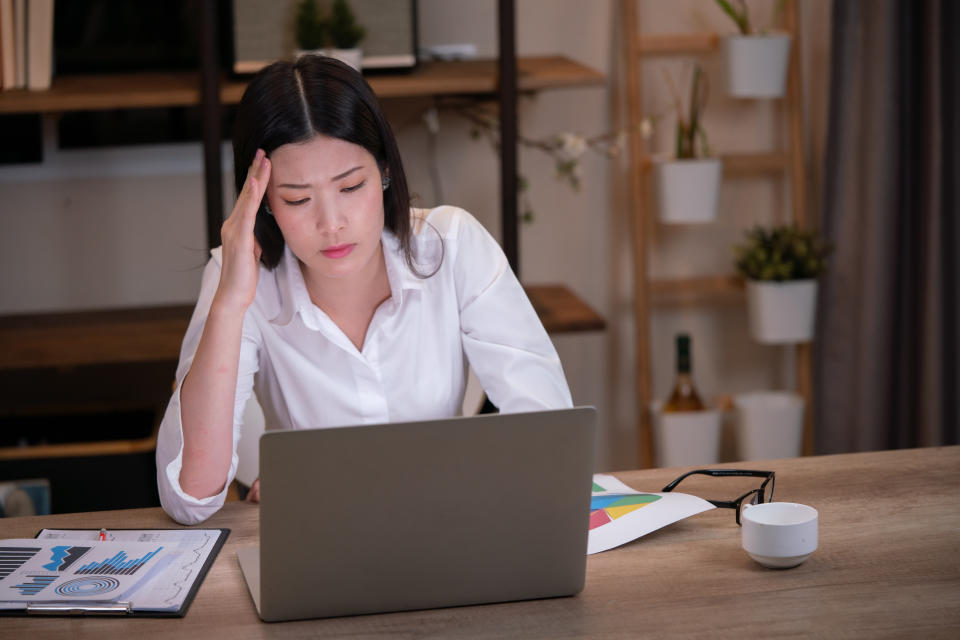 asian woman overtime work and feel shoulder pain in the office