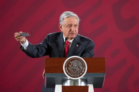 Mexico's President Andres Manuel Lopez Obrador shows a device that had been found in a room used for his meetings in the National Palace headquarters, during his daily news conference in Mexico City