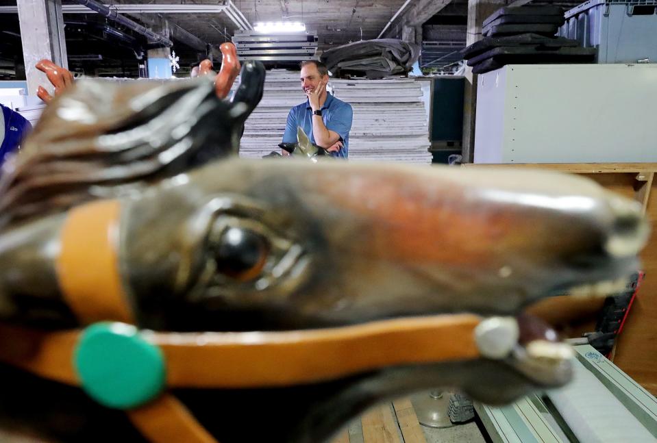 Chris Griffith, downtown operations manager for city of Akron, is framed by one of the many Chapel Hill Mall carousel horses stored in the O'Neil's building that were part of a donation from Industrial Commercial Properties in 2021.