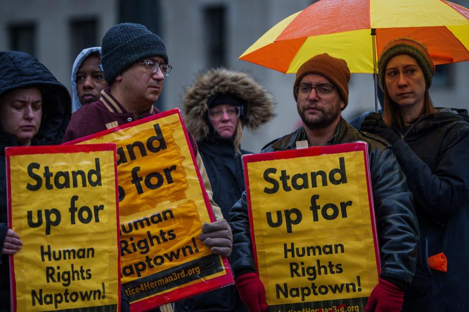 Community members hold signs Monday, Jan. 16, 2023, as a justice rally is held in honor of Herman Whitfield III, along Monument Circle in Indianapolis.