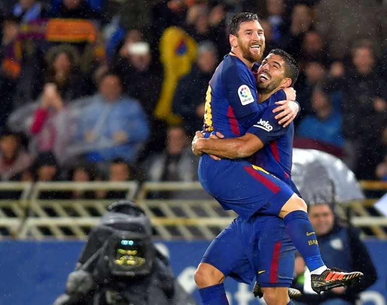 Barcelona's forward Lionel Messi (L) is congratulated by teammate Luis Suarez after scoring against Real Sociedad on January 14, 2018