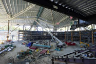 The historic roof of the former KeyArena and a tiered seating area tower over trucks and a crane working Tuesday, Sept. 1, 2020, at what will be center-ice of the Climate Pledge Arena in Seattle, as viewed from the club level of the home of the Seattle Kraken NHL hockey team. Sometime in the late summer or early fall of 2021, the Kraken will open the new facility -- at a cost that will likely total $1 billion by the time it's done -- and become the NHL's 32nd franchise. (AP Photo/Ted S. Warren)