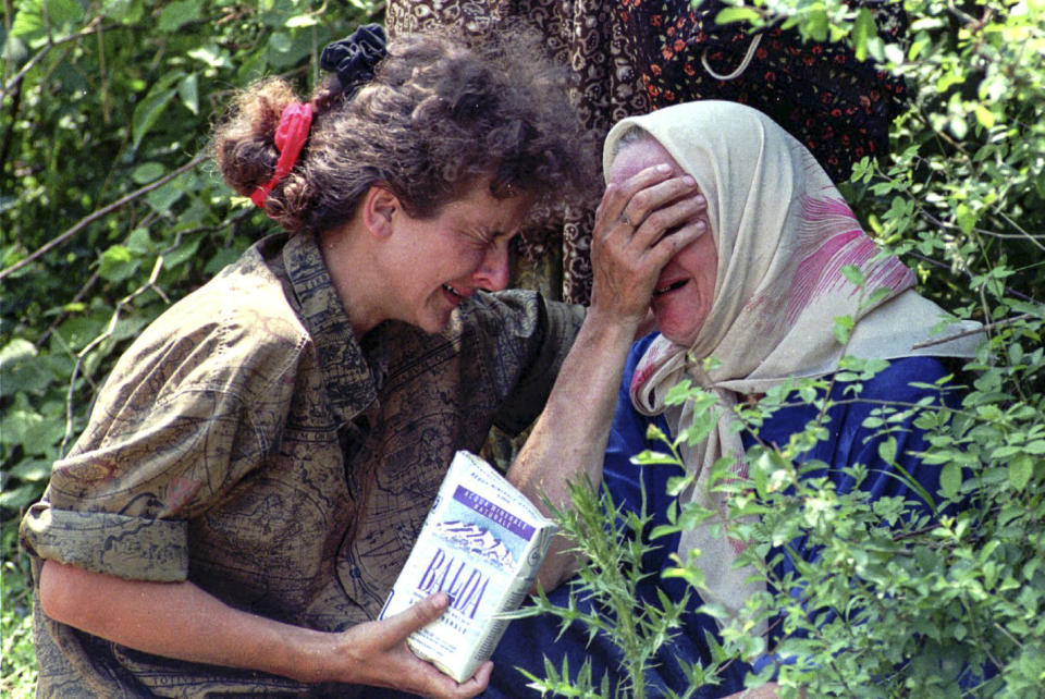 FILE - In this July 13, 1995, file photo a woman and her mother, refugees from Srebrenica, cry worried about the fate of the rest of their family, after reaching a U.N. base near Tuzla, Bosnia. Twenty-six years after the July 1995 Srebrenica massacre, the only episode of Bosnia’s 1992-95 war to be legally defined as genocide, its survivors continue to grapple with the horrors they endured while also confronting increasingly aggressive downplaying and even denial of their ordeal. (AP Photo/Darko Bandic, File)