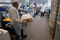 Volunteers prepare meals at Community Servings, which prepares and delivers scratch-made, medically tailored meals to individuals & families living with critical & chronic illnesses, Tuesday, Jan. 12, 2021, in the Jamaica Plain neighborhood of Boston. Food is a growing focus for insurers as they look to improve the health of the people they cover and cut costs. Insurers first started covering Community Servings meals about five years ago, and CEO David Waters says they now cover close to 40%. (AP Photo/Charles Krupa)