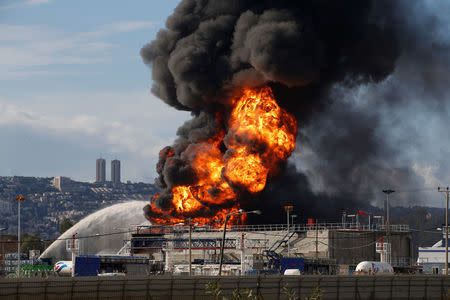 Fire fighters can be seen at work after a fire erupted in a fuel tank at Oil Refineries Ltd in the Israeli northern city of Haifa December 25, 2016. REUTERS/Baz Ratner