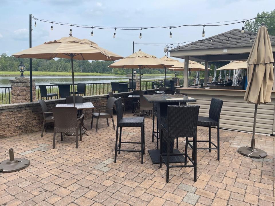 An outdoor seating area is shown at Carlucci's Waterfront in Mount Laurel with the Rancocas Creek as the backdrop.