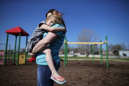 Andrea Smith holds her daughter Norah at a playground in Winthrop Harbor, Illinois, May 9, 2014. REUTERS/Jim Young