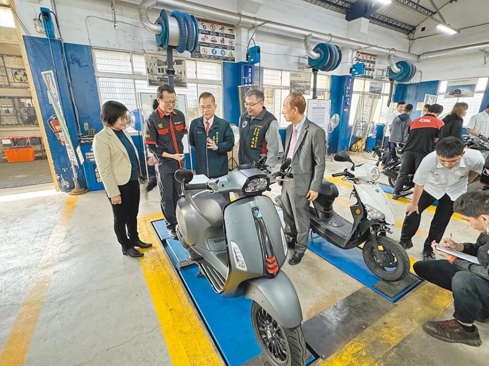 今年初慈幼工商汽車科辦理「台南市動力產學合辦，社區機車義診活動」時，慈幼工商陳素貞校長（如圖左一）、葉志成老師（左二）向臺南市勞工局長王鑫基（左三）與蒞臨貴賓說明同學作業流程。圖／郭文正