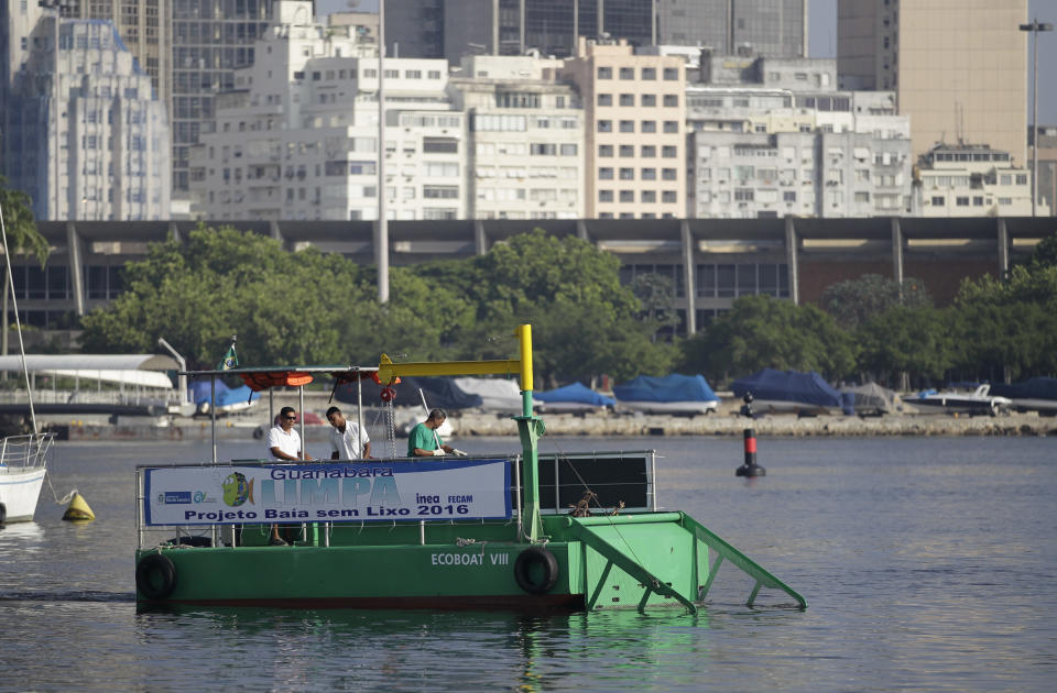 A garbage-collecting barge collects trash at the Guanabara Bay, in Rio de Janeiro, Brazil, Monday, Jan. 6, 2014. The green barge plies the polluted waters of Rio de Janeiro’s Guanabara Bay alongside wooden fishing boats but its catch Monday consisted not of grouper or swordfish but rather plastic bags, empty soda bottles and a discarded toilet seat. The barge is one of three so-called "eco-boats," floating garbage vessels that are a key part of authorities' pledge to clean up Rio’s devastated Guanabara Bay before the city – and the waterway itself – plays host to the 2016 Olympic games. (AP Photo/Silvia Izquierdo)