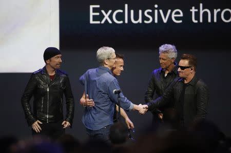 Apple CEO Tim Cook speaks with U2 during an Apple event announcing the iPhone 6 and the Apple Watch at the Flint Center in Cupertino, California, September 9, 2014. REUTERS/Stephen Lam