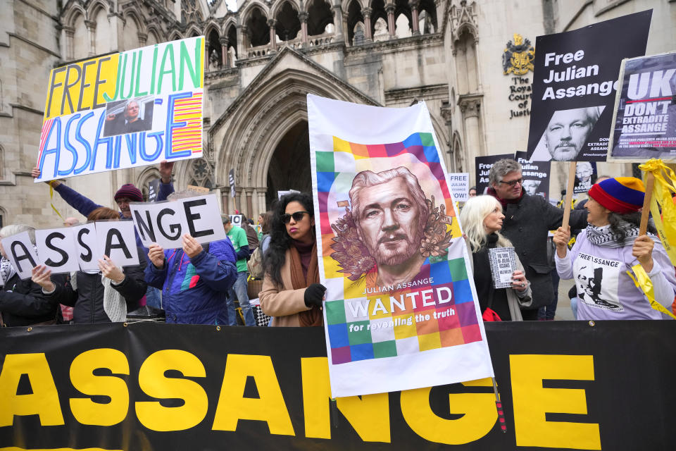 Demonstrators hold banners outside the Royal Courts of Justice in London, Tuesday, Feb. 20, 2024. WikiLeaks founder Julian Assange will make his final appeal against his impending extradition to the United States at the court. (AP Photo/Kirsty Wigglesworth)