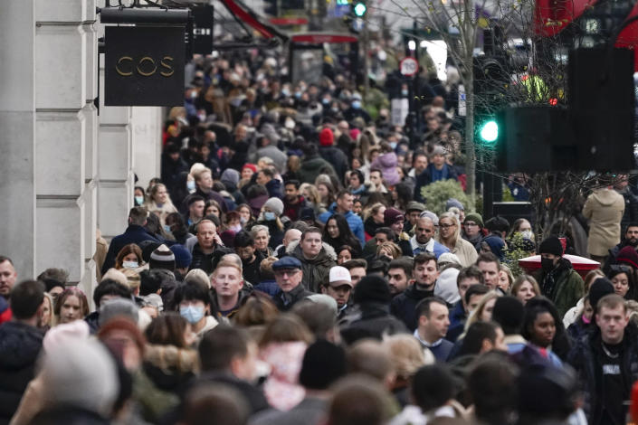 People, some wearing face masks, walk in Regent Street, in London, Sunday, Nov. 28, 2021. Britain's Prime Minister Boris Johnson said it was necessary to take "targeted and precautionary measures" after two people tested positive for the new variant in England. He also said mask-wearing in shops and on public transport will be required. (AP Photo/Alberto Pezzali)