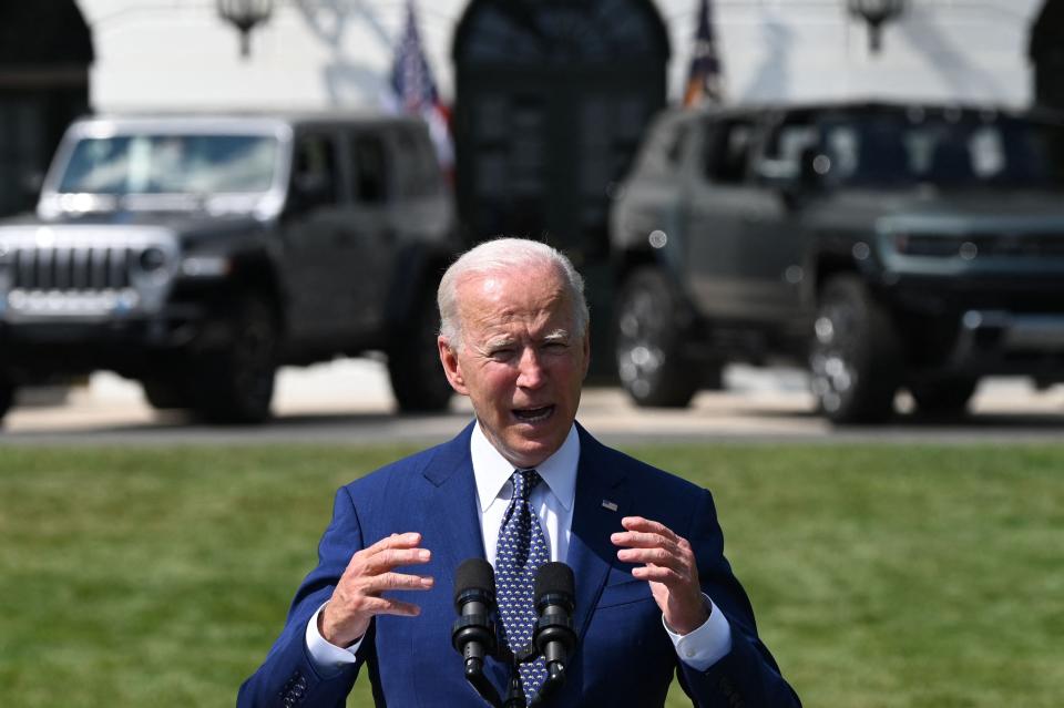 In front of an array of electric vehicles, President Joe Biden discusses steps his administration is taking to strengthen American leadership on clean cars and trucks Aug. 5 at the White House.