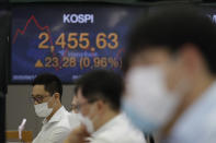 Currency traders watch computer monitors near the screens showing the Korea Composite Stock Price Index (KOSPI), left, and the foreign exchange rate between U.S. dollar and South Korean won at the foreign exchange dealing room in Seoul, South Korea, Thursday, Aug. 13, 2020. Asian shares were mostly higher on Thursday, cheered by the rally on Wall Street that's likely a boon for export-driven regional economies, even as investors worry about the coronavirus pandemic. (AP Photo/Lee Jin-man)