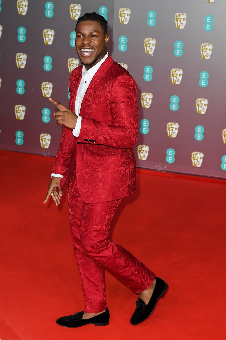 <p>John Boyega brightened up the carpet in a bright red brocade suit.</p>