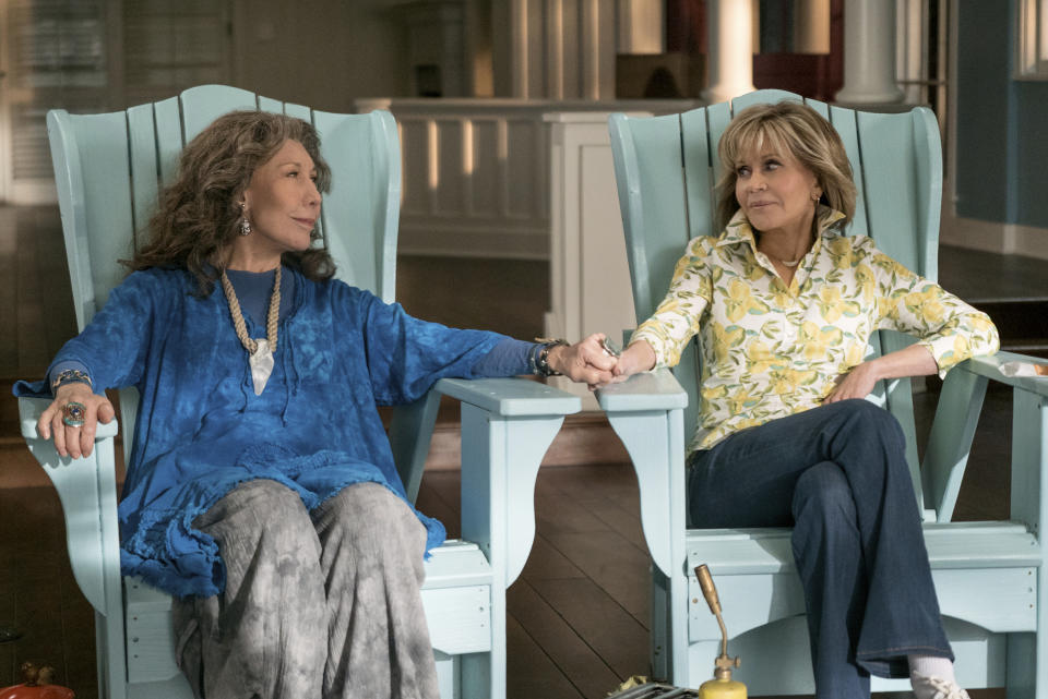 This image released by Netflix shows Lily Tomlin, left, and Jane Fonda in a scene from the comedy series "Grace And Frankie." As the fifth-season adventures of "Grace and Frankie" begin, viewers can rest assured there's more to come. Series creator Marta Kauffman and Netflix said Tuesday, Jan. 15, 2019, that the comedy starring Fonda and Tomlin has been renewed for season six, due in 2020. (Ali Goldstein/Netflix via AP)