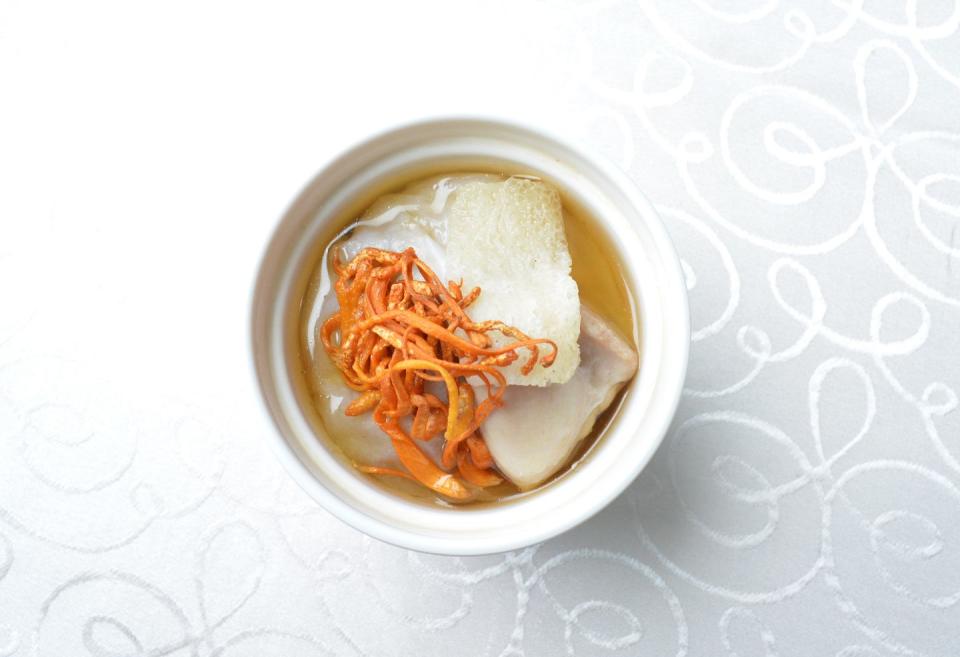 hot double boiled chicken soup with herbal cordyceps flower pot in white background asian halal menu