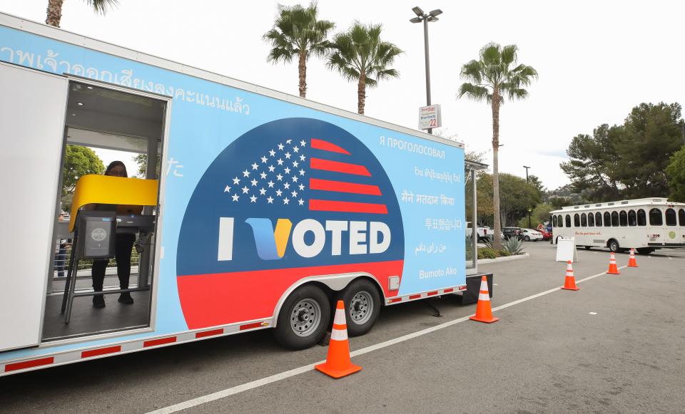 A voter prepares her ballot in a voting booth during early voting for the California presidential primary election at a new L.A. County Mobile Vote Center outside Universal Studios Hollywood