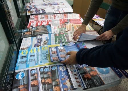 Voters check informative materials on the candidates of the local political parties during primary elections ahead of the presidential elections later this year, in Montevideo